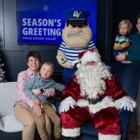 Parents smile with two boys and with Santa and Louie